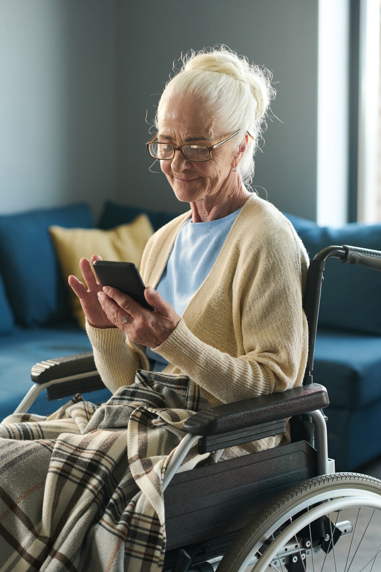 Silver society female representative with disability scrolling in mobile phone